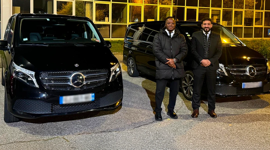 Deux chauffeurs de Go Lyon devant deux Mercedes Classe V noires, de nuit