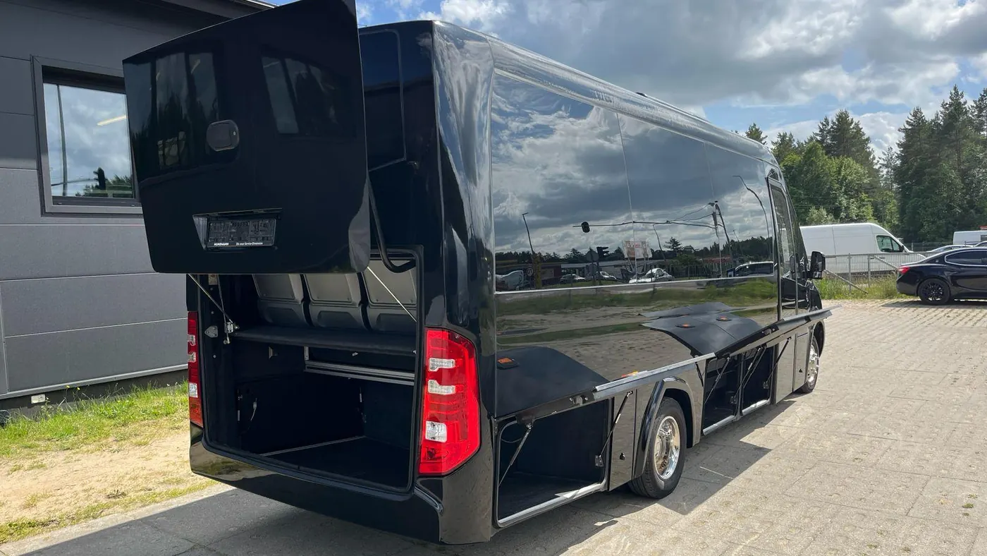 Minibus Mercedes Sprinter noir, hayon et soutes ouverts, prêt au chargement des bagages