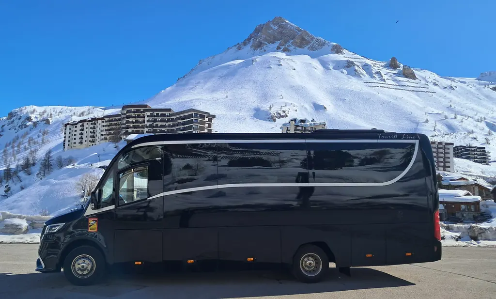 Minibus Mercedes Sprinter noir à l’arrêt dans une station de ski enneigée