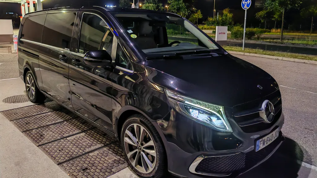 Mercedes Classe V noire de trois quarts avant, la nuit, feux allumés